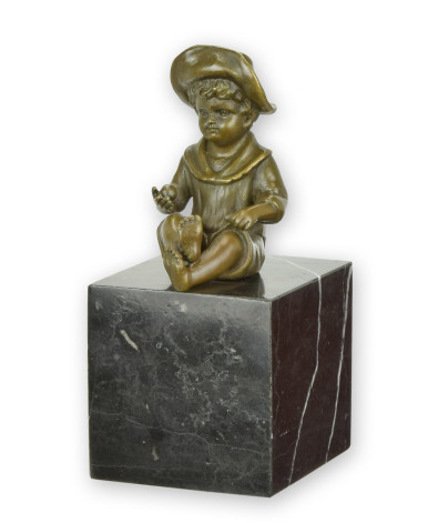 Bronzen beeld van zittende kleine jongen