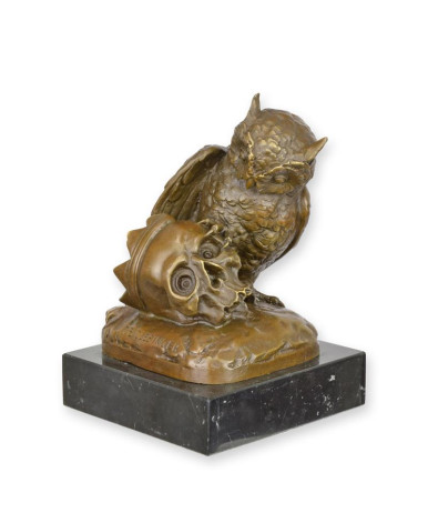 Bronzen beeld van een uil met een schedel