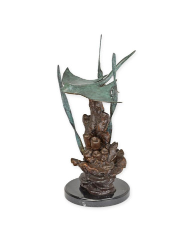 Bronzen pijlstaartrog beeld zwemmend in koraal